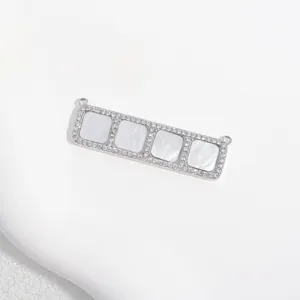 Silver tone rectangular connector pendant with white mother of pearl and cubic zirconia stones.