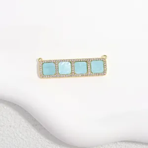 Close-up of rectangular copper pendant with cubic zirconia and blue square inlays for DIY jewelry.