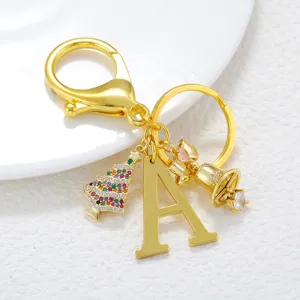 Gold initial letter A keychain with crystal Christmas tree bell and bow charms for women.