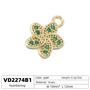 Close-up detail of gold brass five petal flower charm with green crystal stones, DIY jewelry making