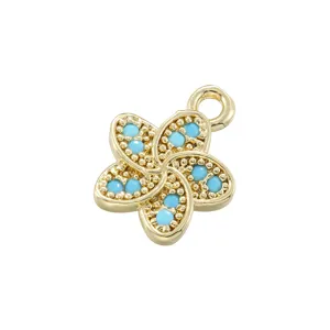 Detailed close-up of a golden five-petal flower pendant with turquoise inlay and beaded texture.