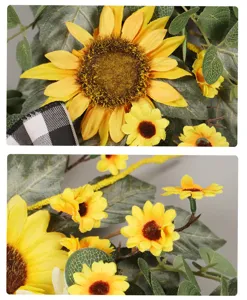 Détail de couronne de tournesol artificielle avec feuilles vertes et nœud écossais pour déco.