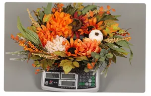Gedetailleerde close-up van de kunstmatige herfstzonnebloemkrans met pompoenen en bessen.