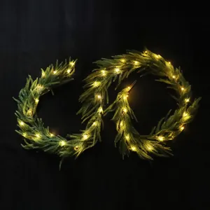 Norfolk pine Christmas garland with warm LED lights, green artificial pine vine for holiday decor.