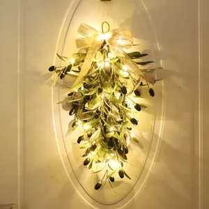 Kunstmatige olijftak tranenkrans met warme LED lampjes en jute strik voor wanddecoratie thuis.