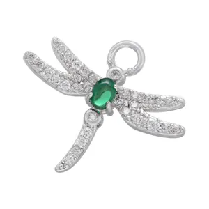 Detailed shot of silver dragonfly pendant paved with sparkling white zirconia and green center gem.
