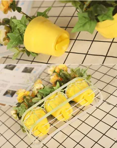 Detail shot of wall-hanging artificial flower pots with a white iron basket and green plants.