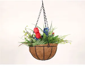 Gros plan de panier suspendu de fleurs artificielles tulipes rouges bleues avec doublure en coco.