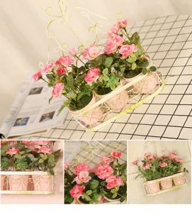 Detail view of American pastoral iron wall hanging flower basket with pink artificial roses.