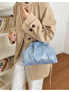 Élégant sac bandoulière coquillage en perles avec tissu bleu texturé et bandoulière chic.