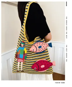 Detailed view of the knit tote bag featuring colorful fish embroidery and chic striped pattern.