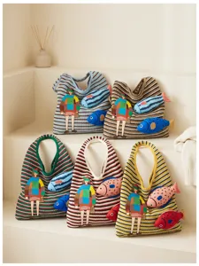 Detailed view of casual knitted tote bag with cute fish and girl cartoon patch design.