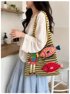 Detailed view of casual knit striped shoulder bag with cute fish embroidery for women.