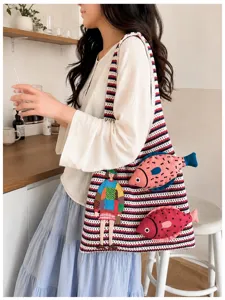 Knit shoulder bag detail view, casual multi-color striped tote with cute fish and figure embroidery.