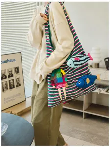 Stylish knitted tote shoulder bag with playful fish appliques, casual commuter style.
