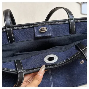 Λεπτομέρεια τζιν τσάντας tote, casual γυναικεία τσάντα ώμου με δέρμα και μεταλλικό κούμπωμα.