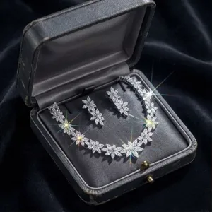 Close-up detail of luxurious sparkling zircon floral necklace and earrings in velvet box.