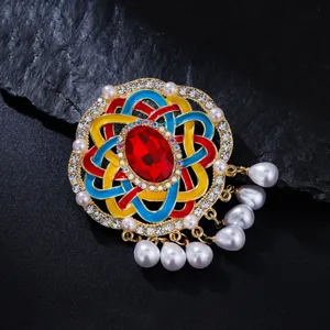 Detail van de gekleurde vintage broche met strass en parelkwastjes voor trui accessoire.