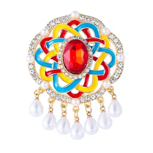 Detailopname van retro gekleurde geëmailleerde Chinese knoop broche met fonkelende strass steentjes.