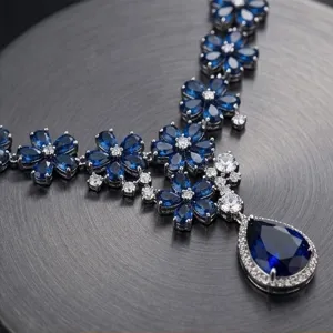 Close-up detail of luxury blue sapphire zirconia floral pendant necklace, sparkling stones.