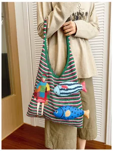Cozy striped knit shoulder bag with cute embroidered girl and fish details, casual tote style.