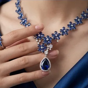 Close-up of sapphire blue cubic zirconia floral necklace with pear pendant and matching ring.