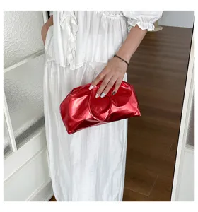 Vue détaillée de la pochette plissée rouge métallique brillante, design en cuir souple.