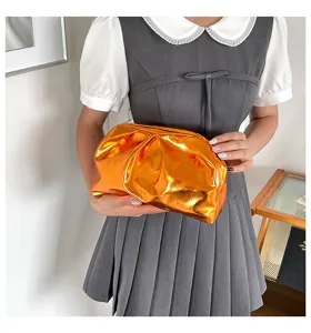 Sac pochette orange métallisé élégant, sac nuage plissé tendance pour femme au style chic quotidien.