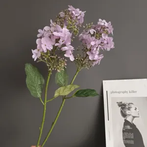 Primer plano detallado de una rama de hortensia lila artificial con pétalos suaves y hojas.