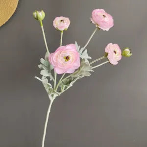 Close-up of pink artificial ranunculus flower detail, showing petal texture and multi-head design.