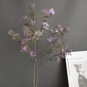 Détail de branche de lilas artificiel, accessoire floral violet pour déco intérieure.