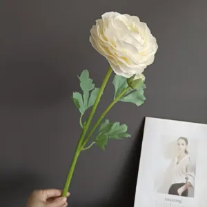 Close-up of artificial ranunculus flower, two-head design with green leaves for decor.