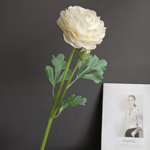 Detailed close-up of artificial ranunculus flower with realistic green leaves and delicate petals.
