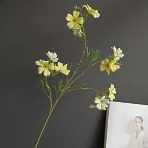 Vista dettagliata di un ramo di fiori selvatici artificiali, gialli e bianchi, per la decorazione.