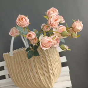 Closeup detail of artificial pink roses in woven basket, Nordic home decor flower display.