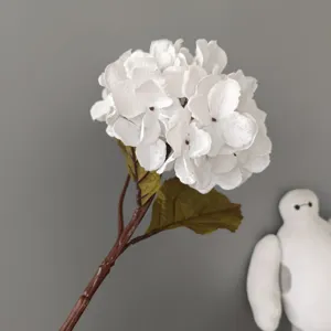 Primo piano dettagliato del ramo di ortensia bianca artificiale con petali realistici.