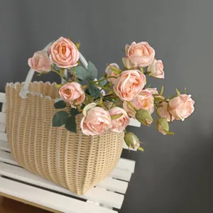 Artificial pink rose bouquet with woven basket, Nordic style home decor detail view.