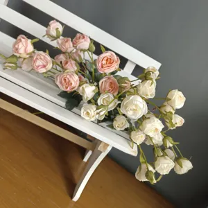 Close-up detail of artificial crepe fabric rose bouquet, featuring pink and white petals and leaves.