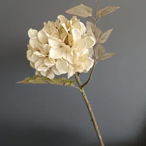 Primo piano dettagliato della testa di fiore di ortensia finta e delle foglie strutturate.