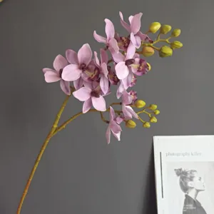 Primo piano dettagliato di un ramo di orchidea artificiale con fiori viola realistici.