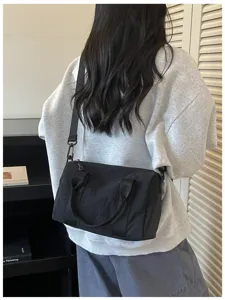 Detailed shot of black casual crossbody travel shoulder bag with durable straps and zipper.