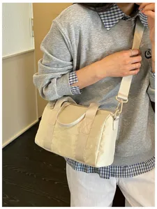 Beige nylon barrel crossbody bag, stylish lightweight shoulder bag for daily commute.