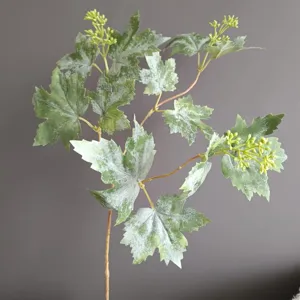 Primer plano detallado de una rama de hoja de vid artificial escarchada para decoración.