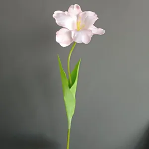 Primer plano detallado de una flor de tulipán rosa artificial con tallo verde decorativo.