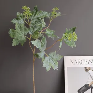 Primer plano de rama de hoja de planta artificial, follaje verde y cogollos para decoración.