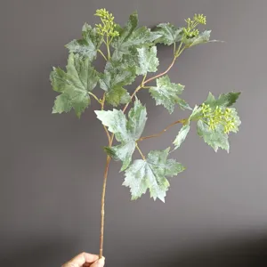 Rama de planta verde artificial con hojas de vid escarchadas para decoración.