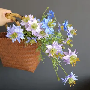Artificial wildflower detail view, blue and purple faux floral bouquet in woven basket.