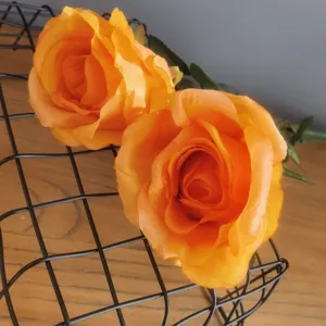 Gros plan détaillé de la fleur de rose artificielle orange pour décoration intérieure.