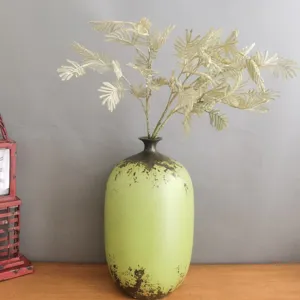 Detailed view of artificial botanical fern leaves branch for home decor and floral arrangement.