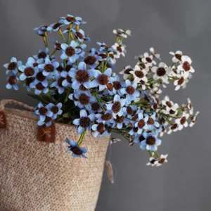 Artificial blue and white daisy flower bouquet detail shot with flocked core for home decor.